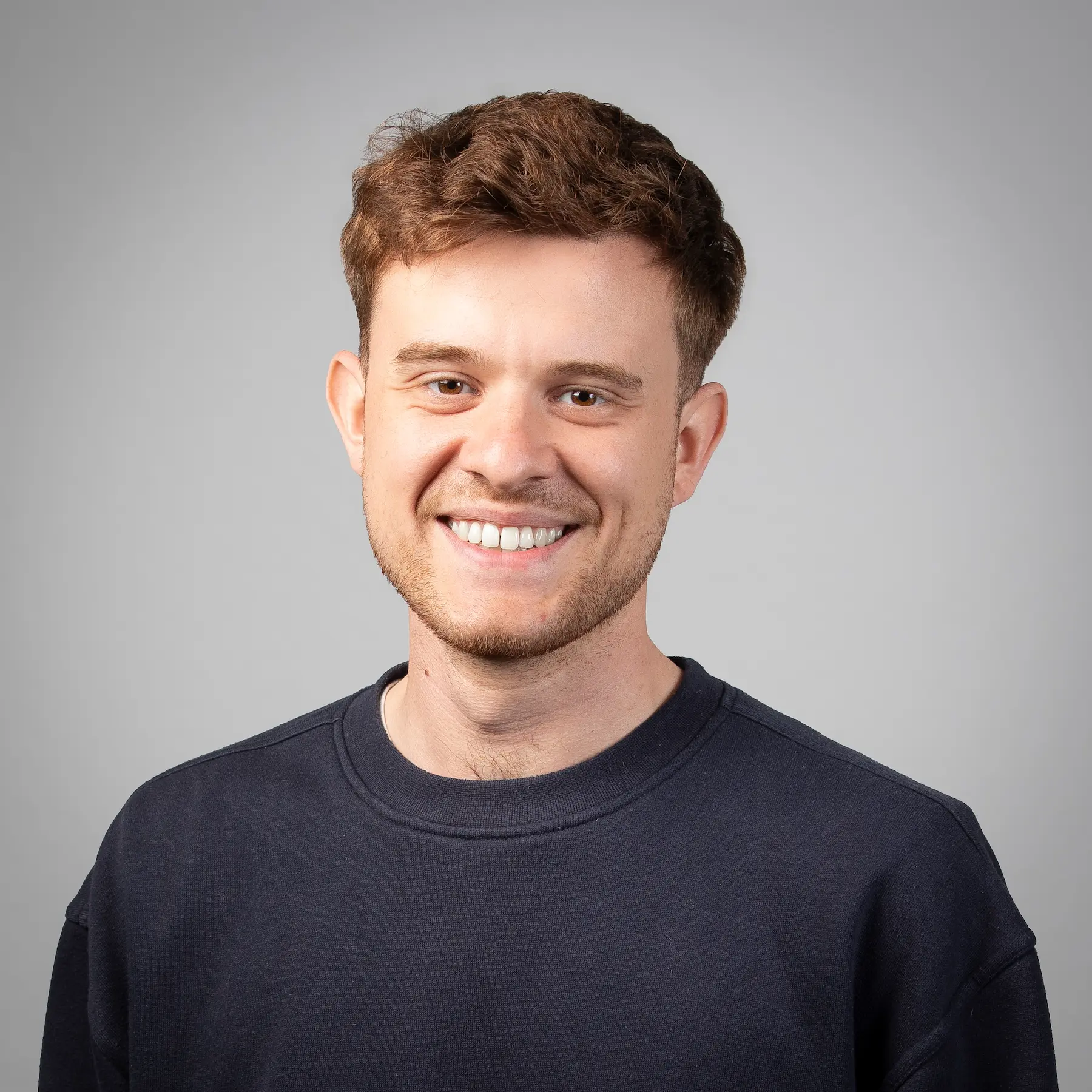 Gerrit Claßen posiert für ein professionelles Portraitfoto vor einem hellen Hintergrund.