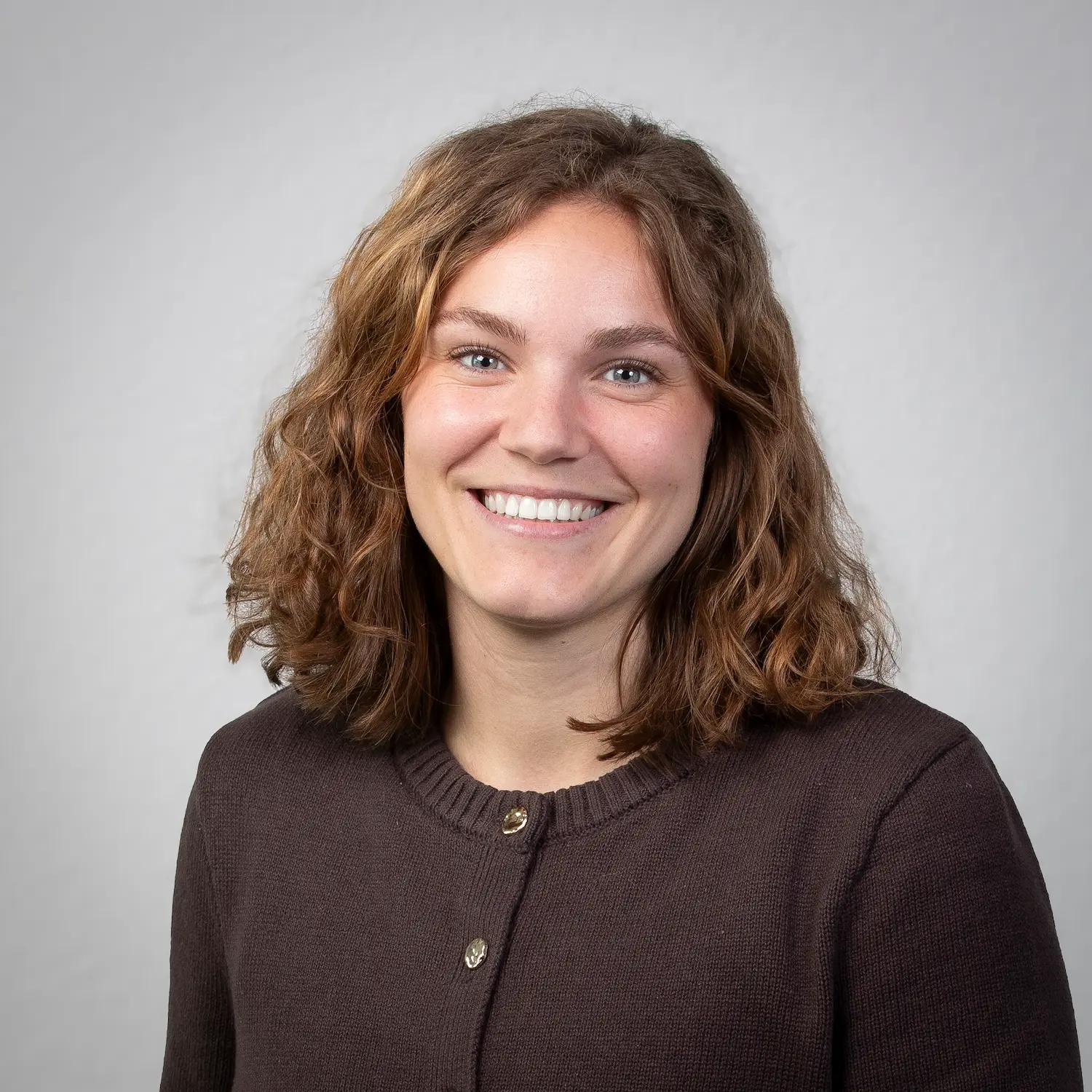 Hanna Meinikmann posiert für ein professionelles Portraitfoto vor einem hellen Hintergrund.
