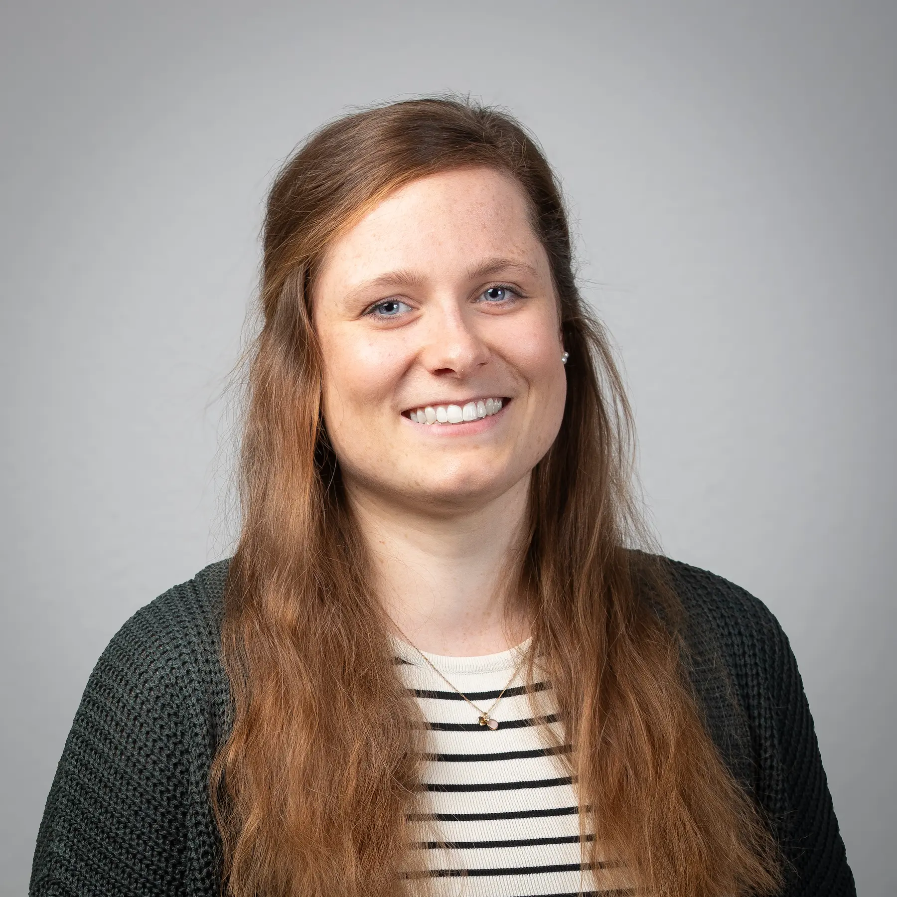 Julia Waldmann posiert für ein professionelles Portraitfoto vor einem hellen Hintergrund.