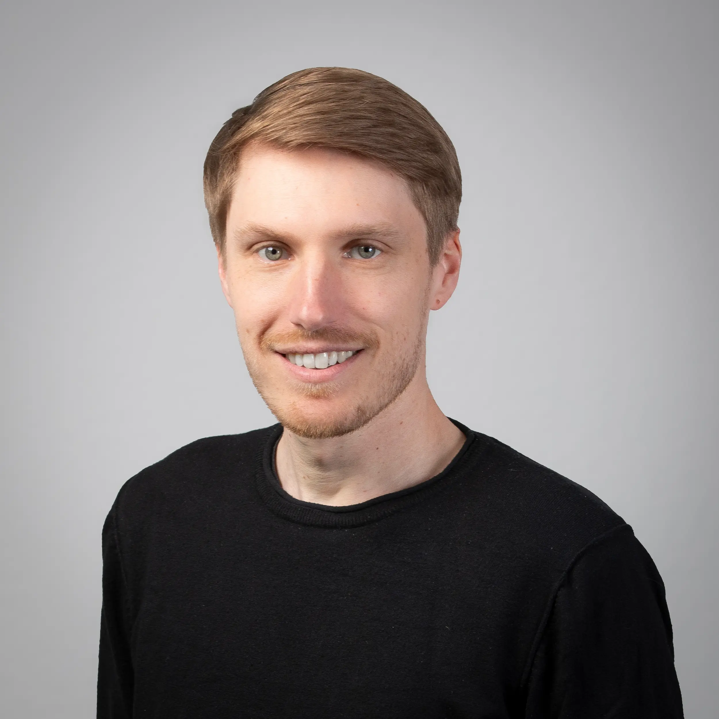 Niklas Krieger posiert für ein professionelles Portraitfoto vor einem hellen Hintergrund.