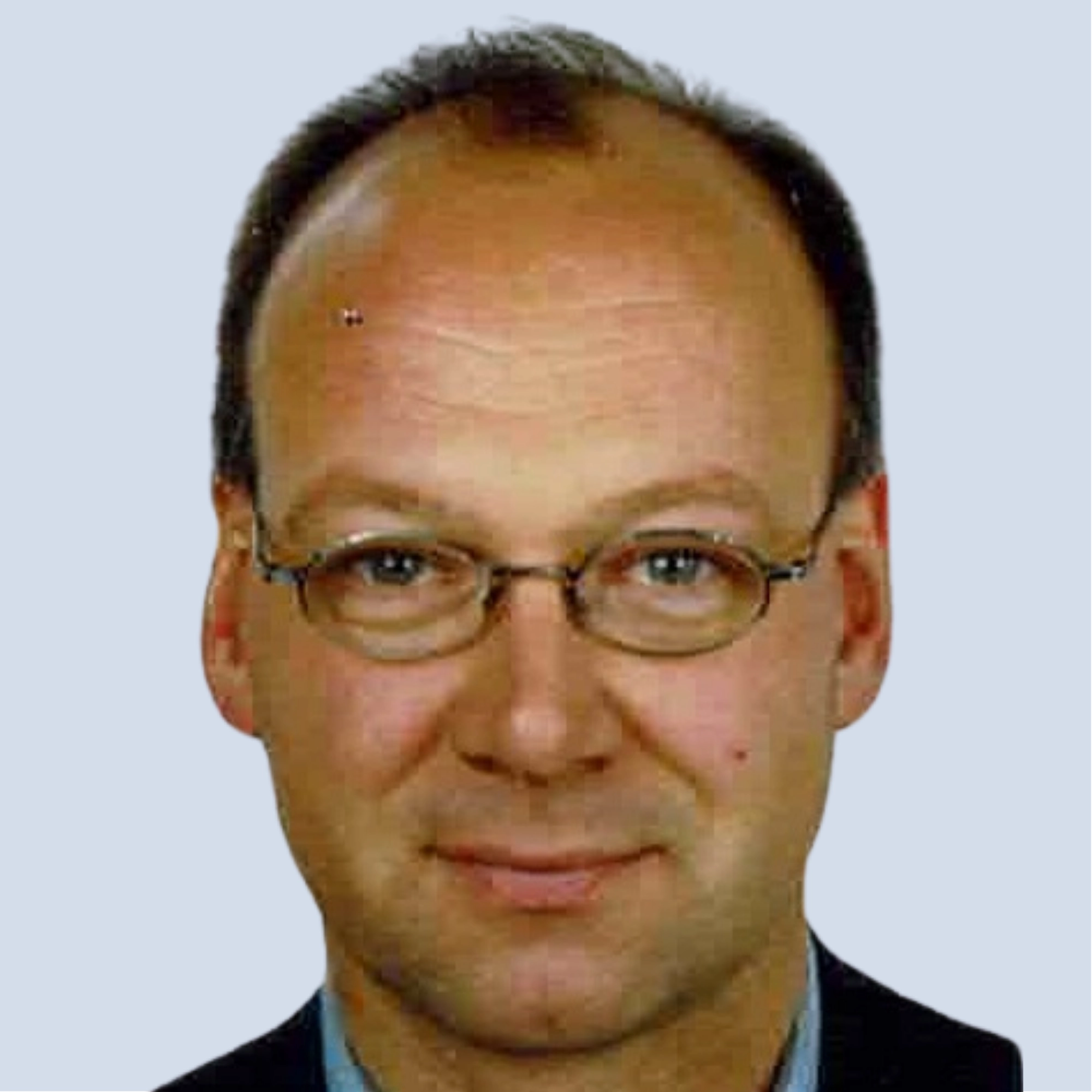 LSB_Hauptausschuss_Bjoern Jeschke Björn Jeschke lächelt in die Kamera, trägt Brille, Portrait vor einem hellblauen Hintergrund